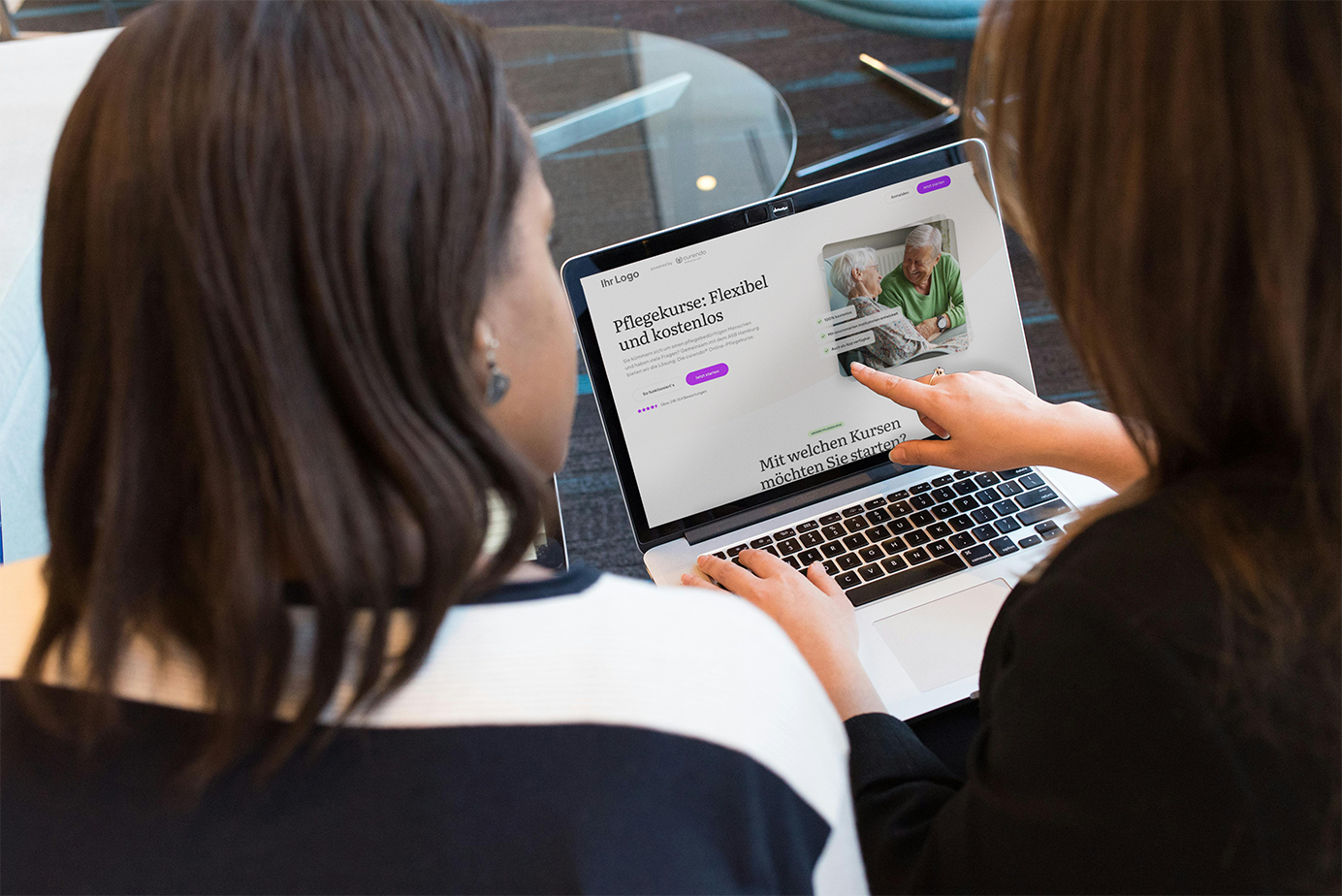 Zwei Mitarbeiterinnen betrachten am Laptop die curendo-Website zur Pflegekurs-Auswahl