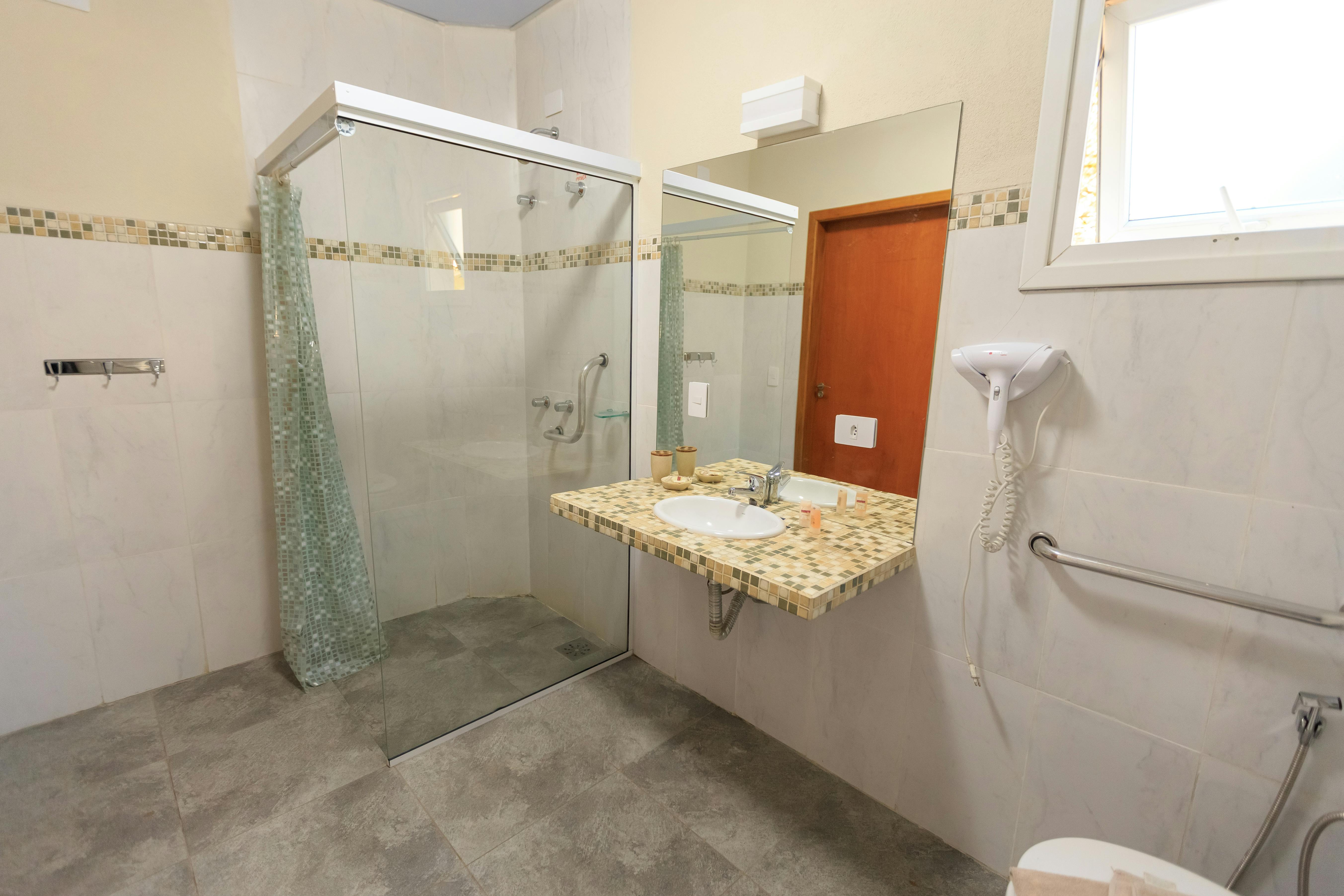 Barrierearmes Badezimmer mit ebenerdiger Dusche, Haltegriffen und unterfahrbarem Waschbecken