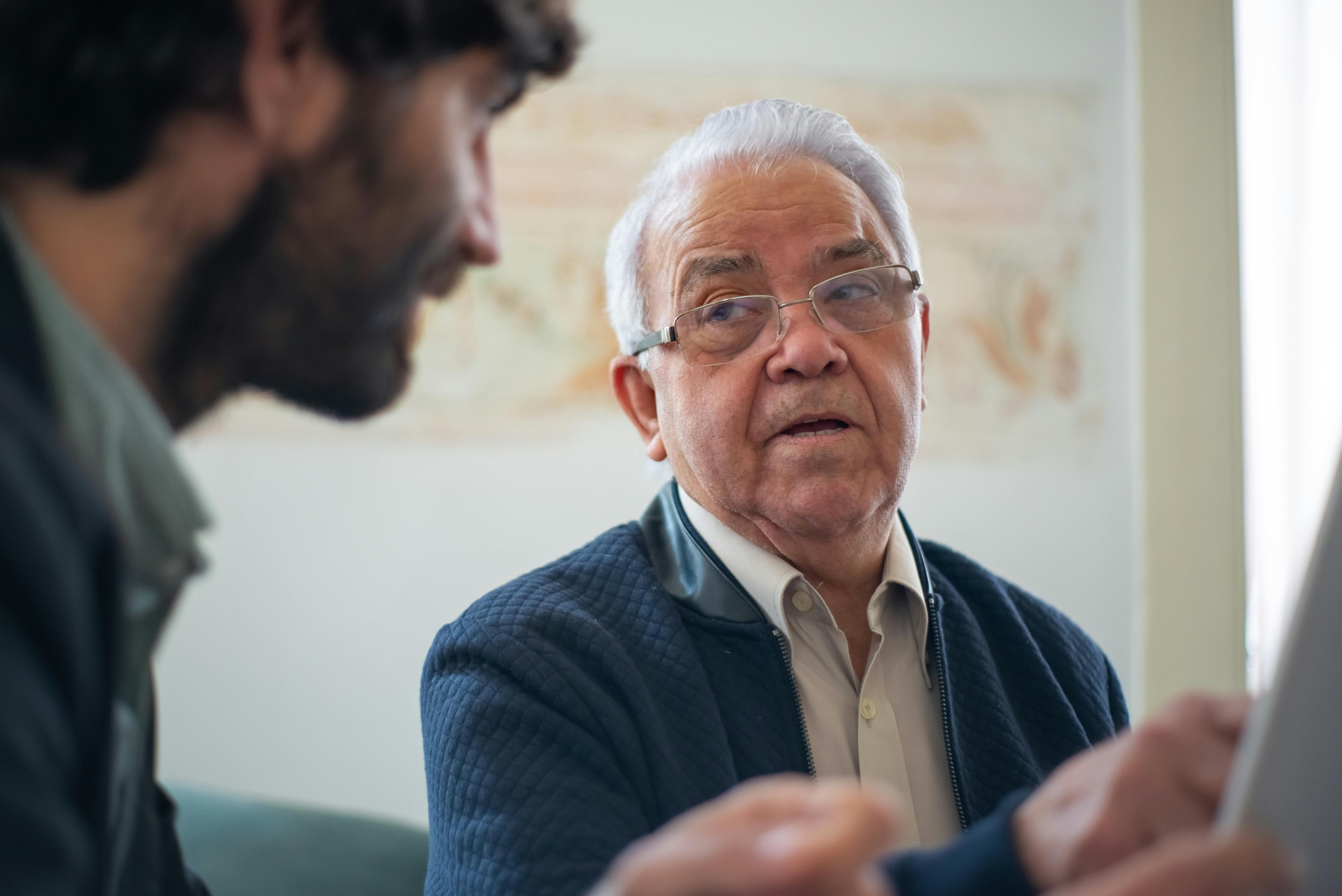 &Auml;lterer Mann im Gespr&auml;ch mit einem j&uuml;ngeren Mann w&auml;hrend einer Beratung